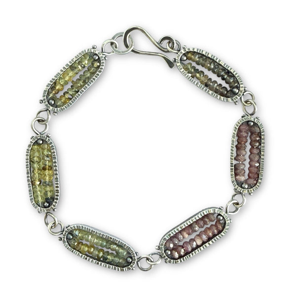 Silver bracelet with oval gemstones on a white background
