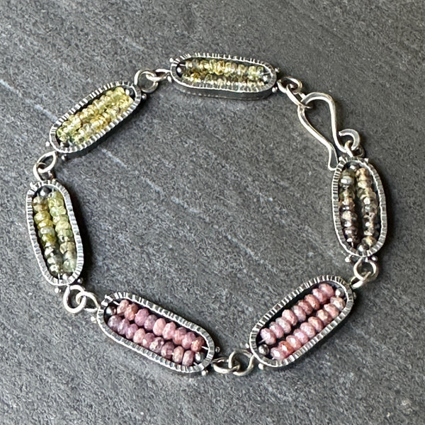 Bracelet with green and pink beads on a gray surface