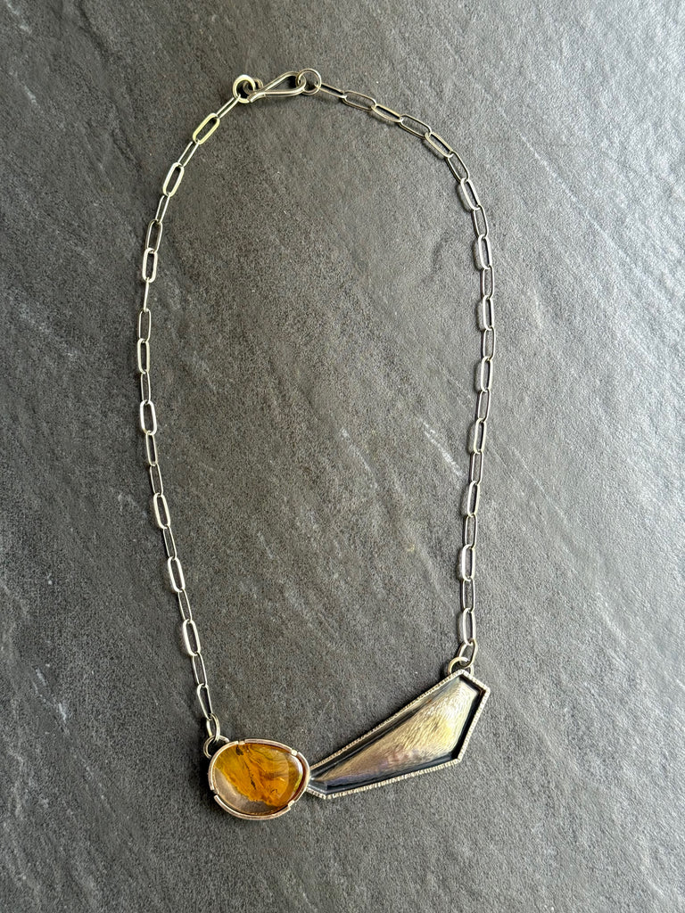Necklace with asymmetrical pendant on a grey background